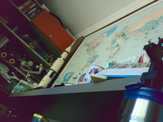 The test photo: a shelf with a Saturn V model, a world map, and a NASA mug (640×480)